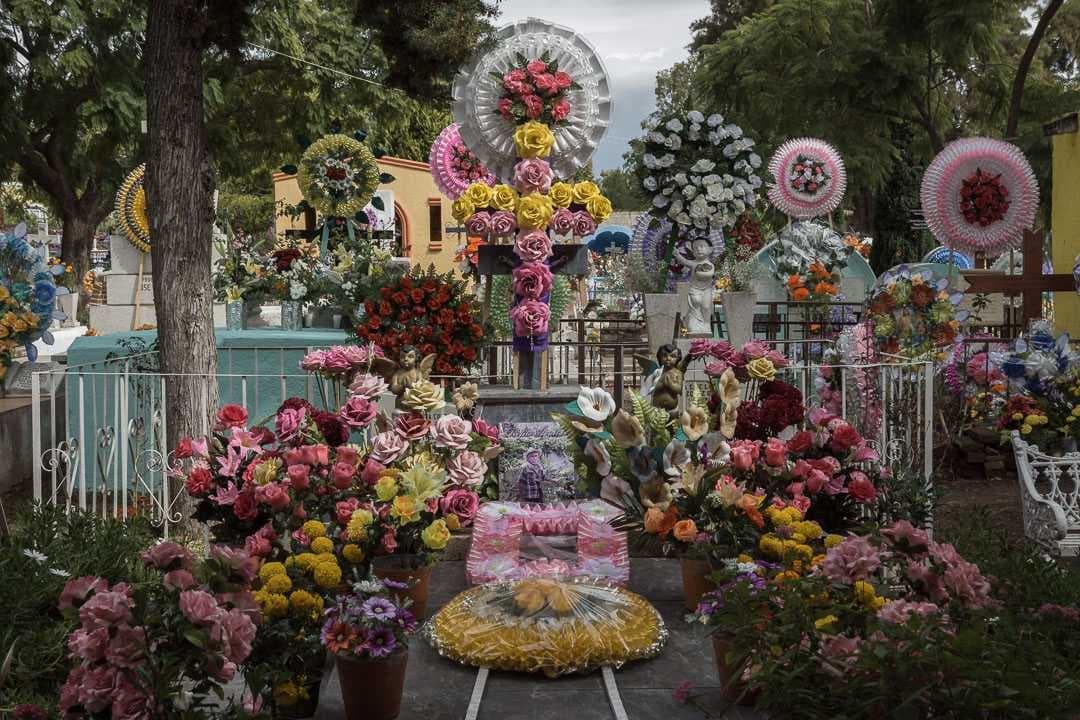 Flowers, both artificial and real, line a grave in the graveyard in San Antonio Tlayacapan.