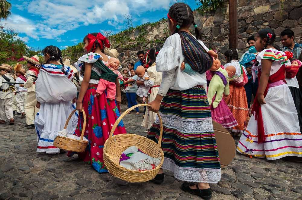 Girls march through the streets of Ajijic, Jalisco, Mexico, during the 2014 Revolution Day parade. Carrying baby dolls on their backs the old-fashioned way with rebozos, they represent the famous adelitas, women of the Mexican Revolution.